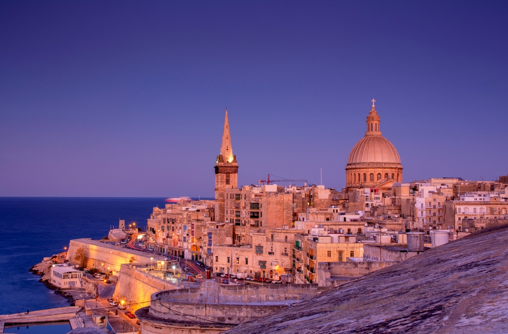 View from above of the golden dome of church and roofs with church of Our Lady of Mount Carmel and St. Paul's Cathedral in Valletta, Malta.