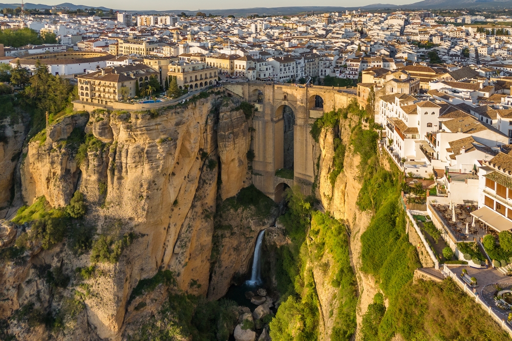 Ronda, Spain. Aerial view of the New Bridge over Guadalevin River in Ronda medieval town at sunrise, Andalusia, Spain. Famous UNESCO heritage city and Puente Nuevo bridge at sunset. 