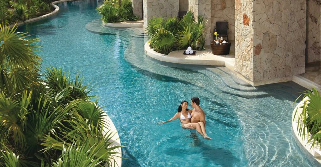 couples lounging in the pool at a luxury all inclusive resort