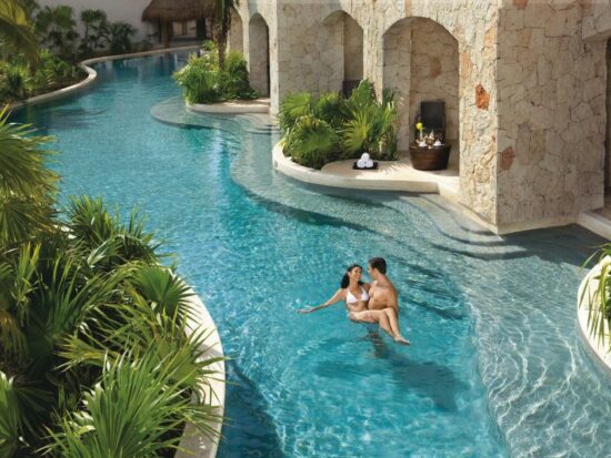 couples lounging in the pool at a luxury all inclusive resort