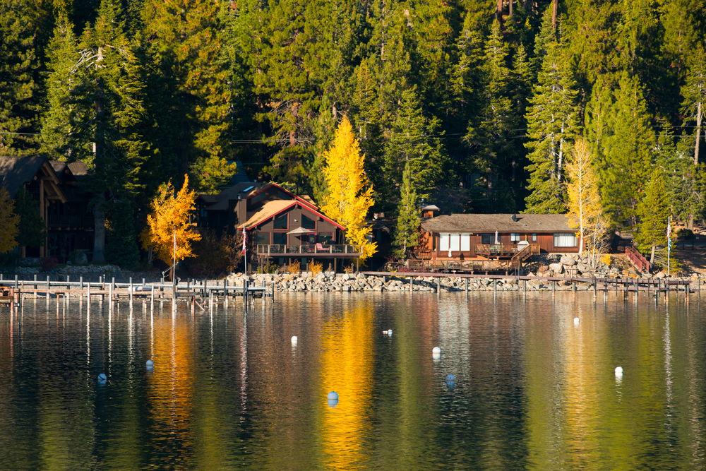 the lake in the foreground and waterfront houses and large trees in the background in North Lake Tahoe near Tahoe City, one of the best small towns in California