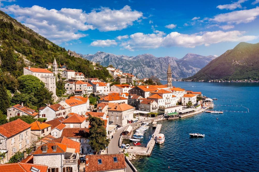 View of the historic town of Perast at famous Bay of Kotor on a beautiful sunny day with blue sky and clouds in summer, Montenegro.