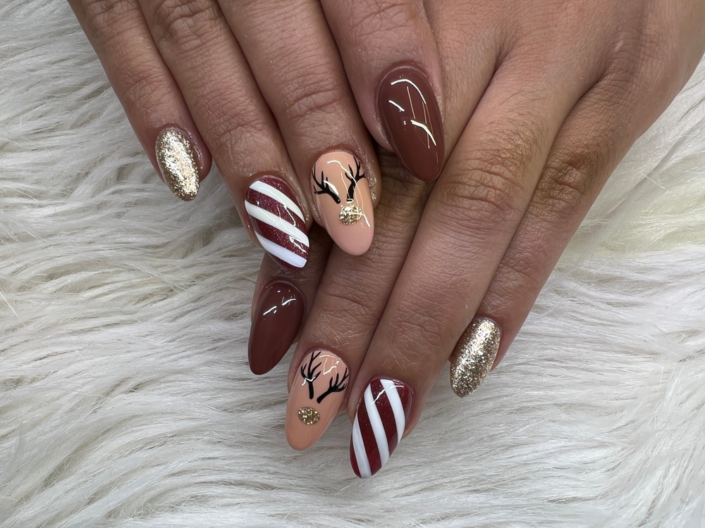 Christmas nail art, brown with glitter and a reindeer. One of the Festive Christmas Nail Ideas 