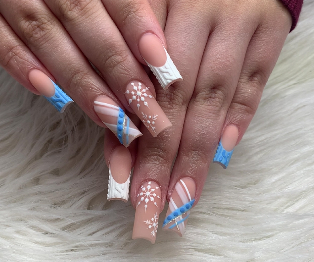 Manicure with snowflakes on nails with colored gel on a square shaped nails. Christmas festive nail art.