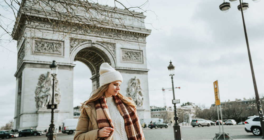 woman standing in front of arc de triomphe