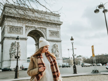 woman standing in front of arc de triomphe