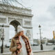 woman standing in front of arc de triomphe