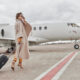 woman wearing long coat standing outside of airplane