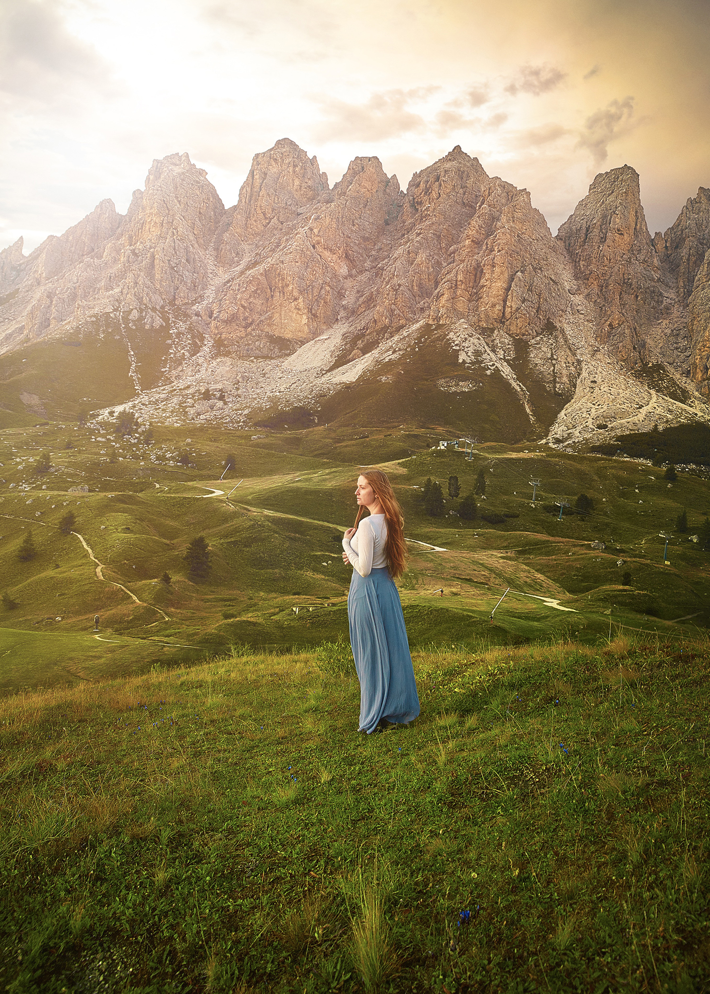 a girl in long sleeve top and blue dress overlooking the Italian Dolomites is perfect for chillier weather if looking at what to wear to Italy in Summer