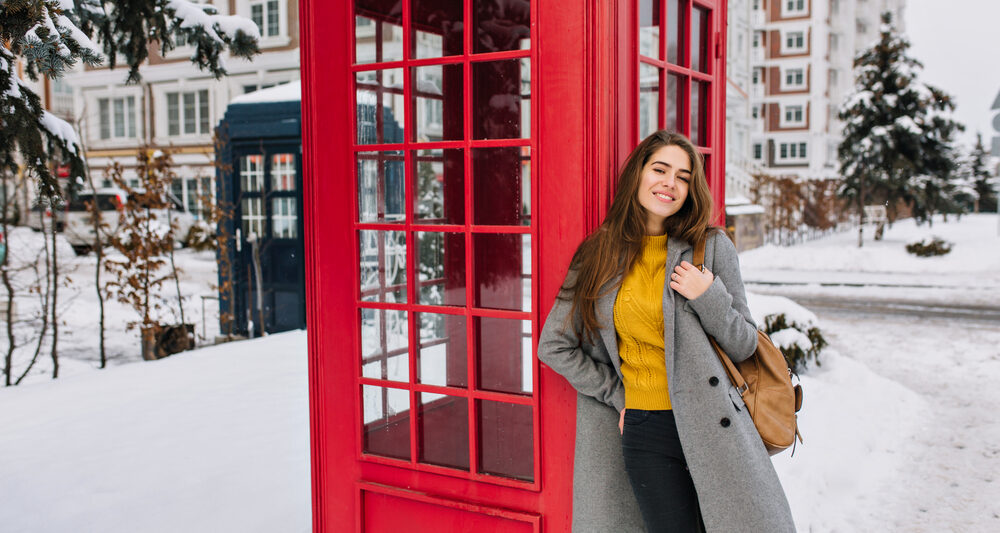 woman standing in front of post box in london in January