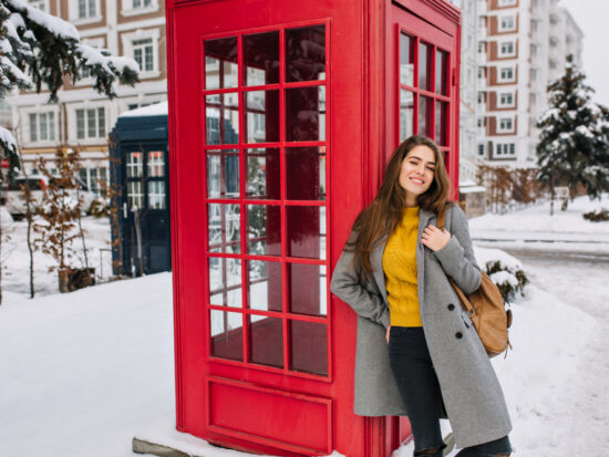 woman standing in front of post box in london in January