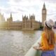 woman in yellow sweater standing in front of big ben in london in spring