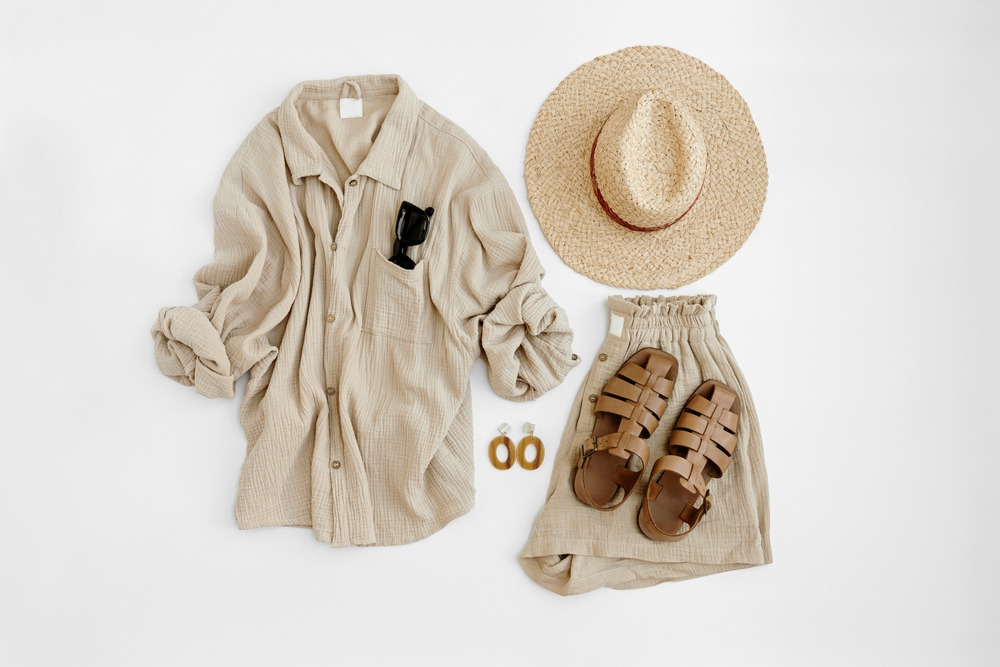 a capsule wardrobe showing 2 piece linen set in beige, straw hat and sandals