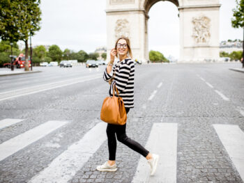 woman standing at crosswalk in paris wearing a cute striped top