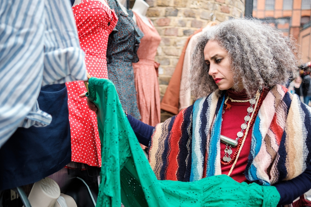 A women searches the outfits in Camden marker: her thick scarfs and graphic outfits allow her to fit in with the eccentric vibe of the market, so she knows what to wear in London in February. 