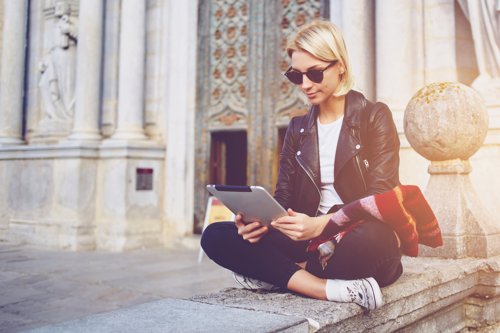 When looking for what to wear in London in February for museum days, choose comfort like this woman: her trainers are made for walking, her pants are flexible, and she has on sunglasses, a scarf and a jacket for easy indoor outdoor transitions. 