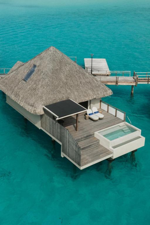 Stylish water bungalow with a pool and loungers. 