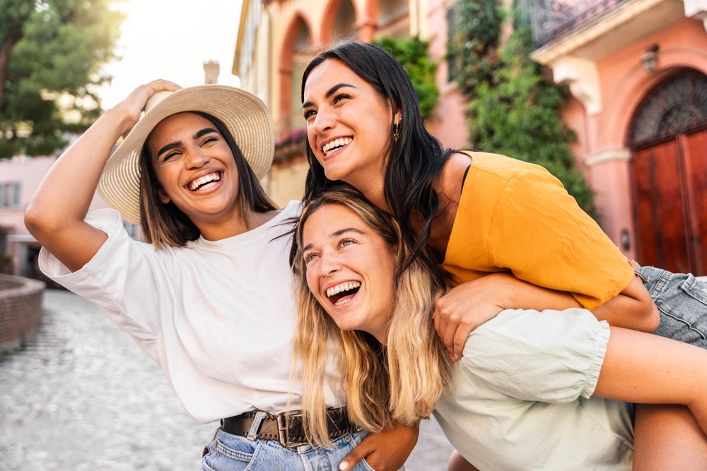 Group of three friends laughing Rome wearing summer clothes.