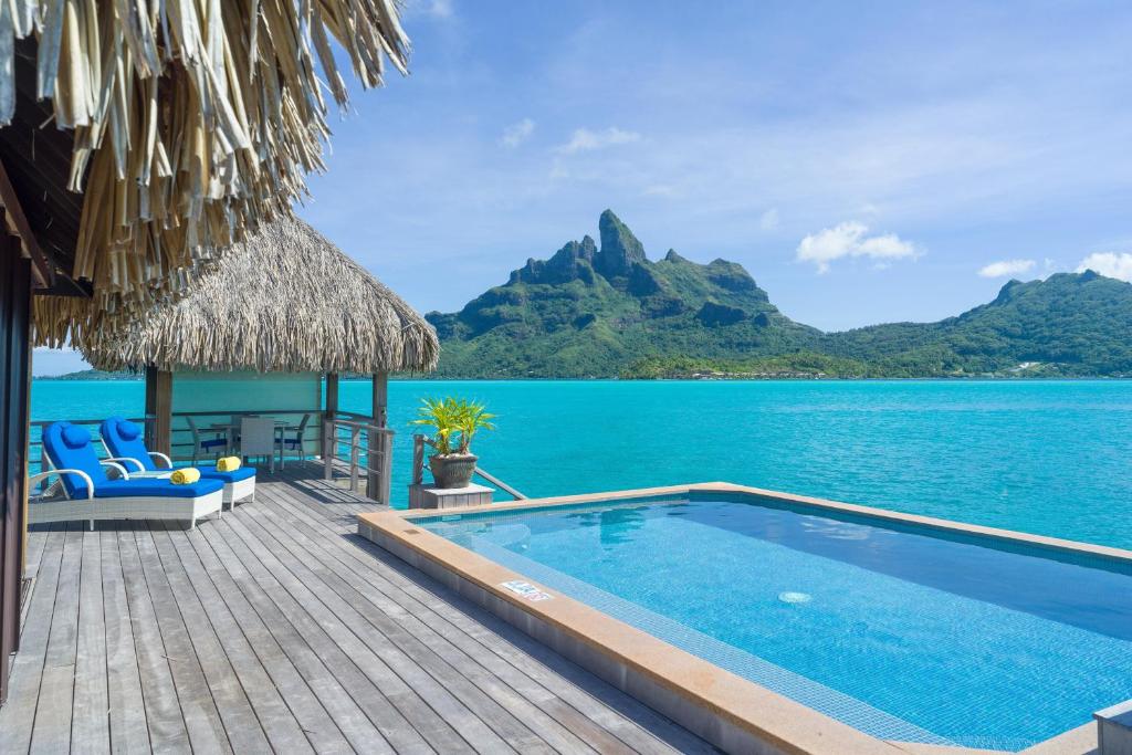 View from a water bungalow out to sea. There is a deck, pool and chairs.  One of the best resorts in Bora Bora