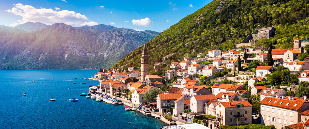 The seaside town of Kotor with stunning mountains, ocean, and village with terracotta roofs built into the hillside is perfect Eastern European two week itinerary