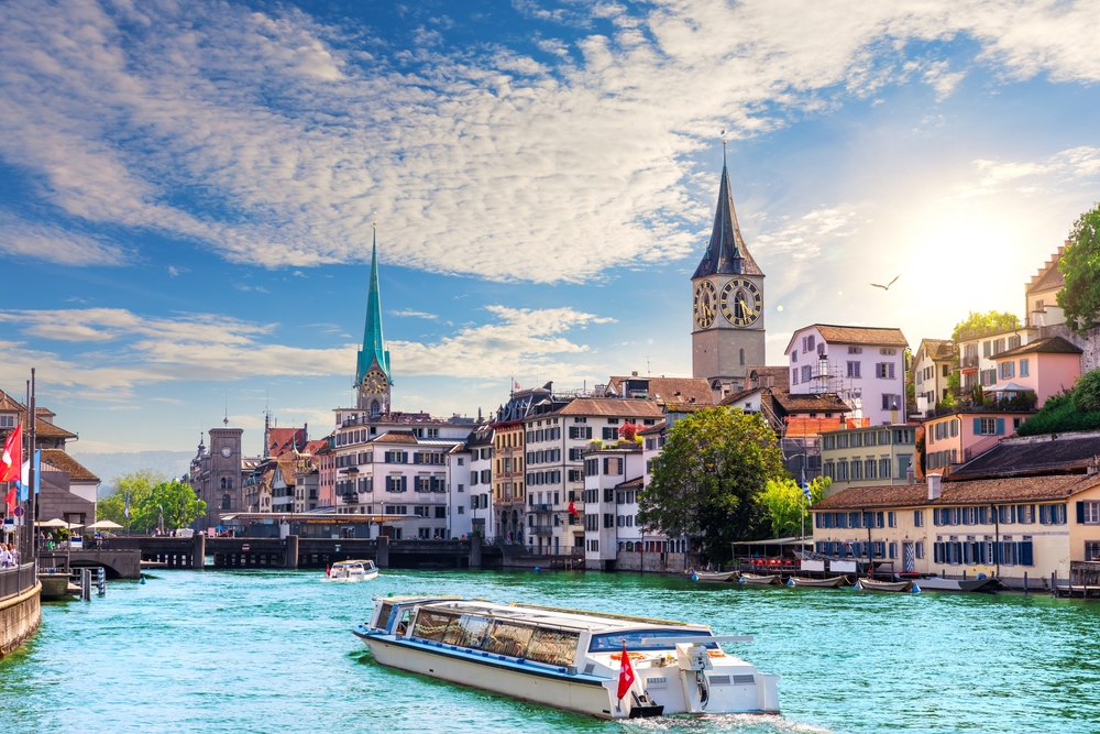 a view of Lake Switzerland with a boat and the architecture of the city 