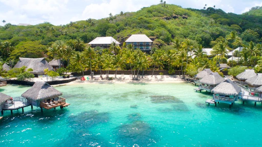 A bay with palm trees and water bungalows and buildings in the background.  One of the best resorts in Bora Bora