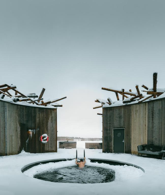 plunge pool in the snow with person getting out of the pool. 