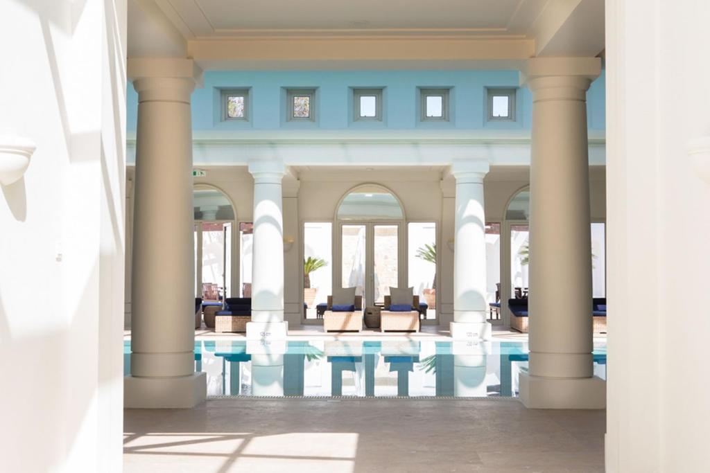 View of a pool and spa with pillars and arches. 