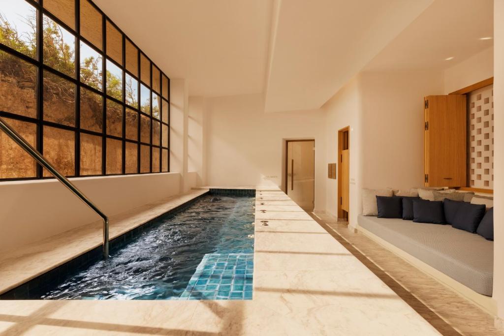 View of a pool and a sofa in a spa room.  