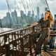 Worrying about what to wear in the city in the summer isn't needed: channel this model who stands on a bridge, a striped jumpsuit, and a matching belt and shoes on, NYC cityscape in the background.