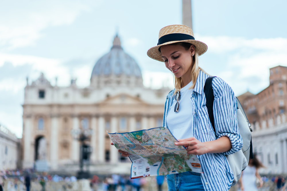 In Rome, a woman doesn't  what to wear in the city in the summer, as she pairs her denim shorts with a casual white tee, and throws on a striped button down, ready to explore. 