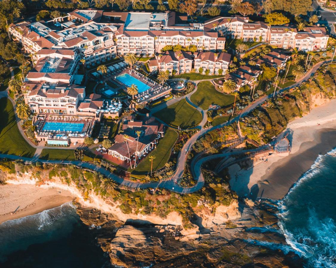 an Ariel view of the Montage Resort and Spa perched above the ocean with outdoor pools, and  views of the pacific ocean below