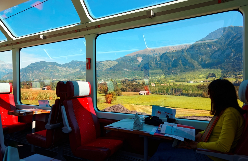 a woman sitting inside one of the scenic rides with large picture windows to take in the view