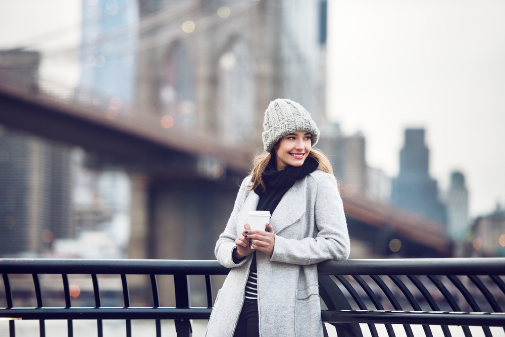 When wondering what to wear in New York City in winter, channel this inner model, who stands by the Brooklyn bridge in her beanie, wool coat, scarf and sweater. 