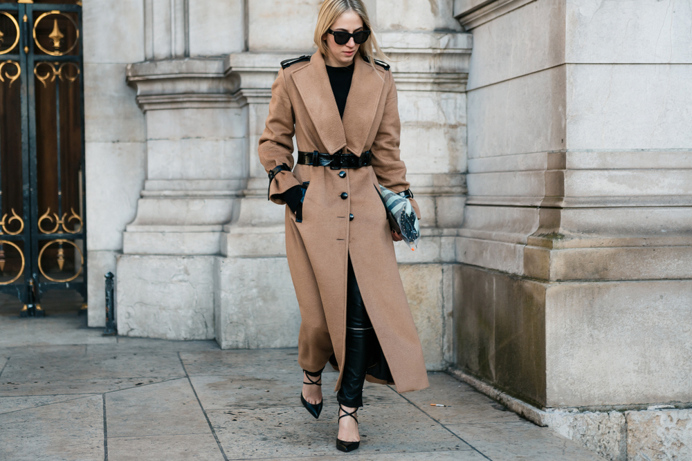 This model knows what to wear in Paris in winter with he belted wool coat, leather pants, and fashionable black sandals. 