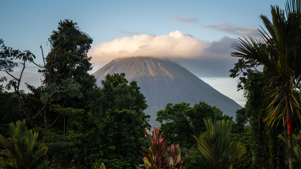 Where to Honeymoon On A Budget. Sunset view of Arenal Volcano and tropical rain forest near La Fortuna, in Costa Rica, central America