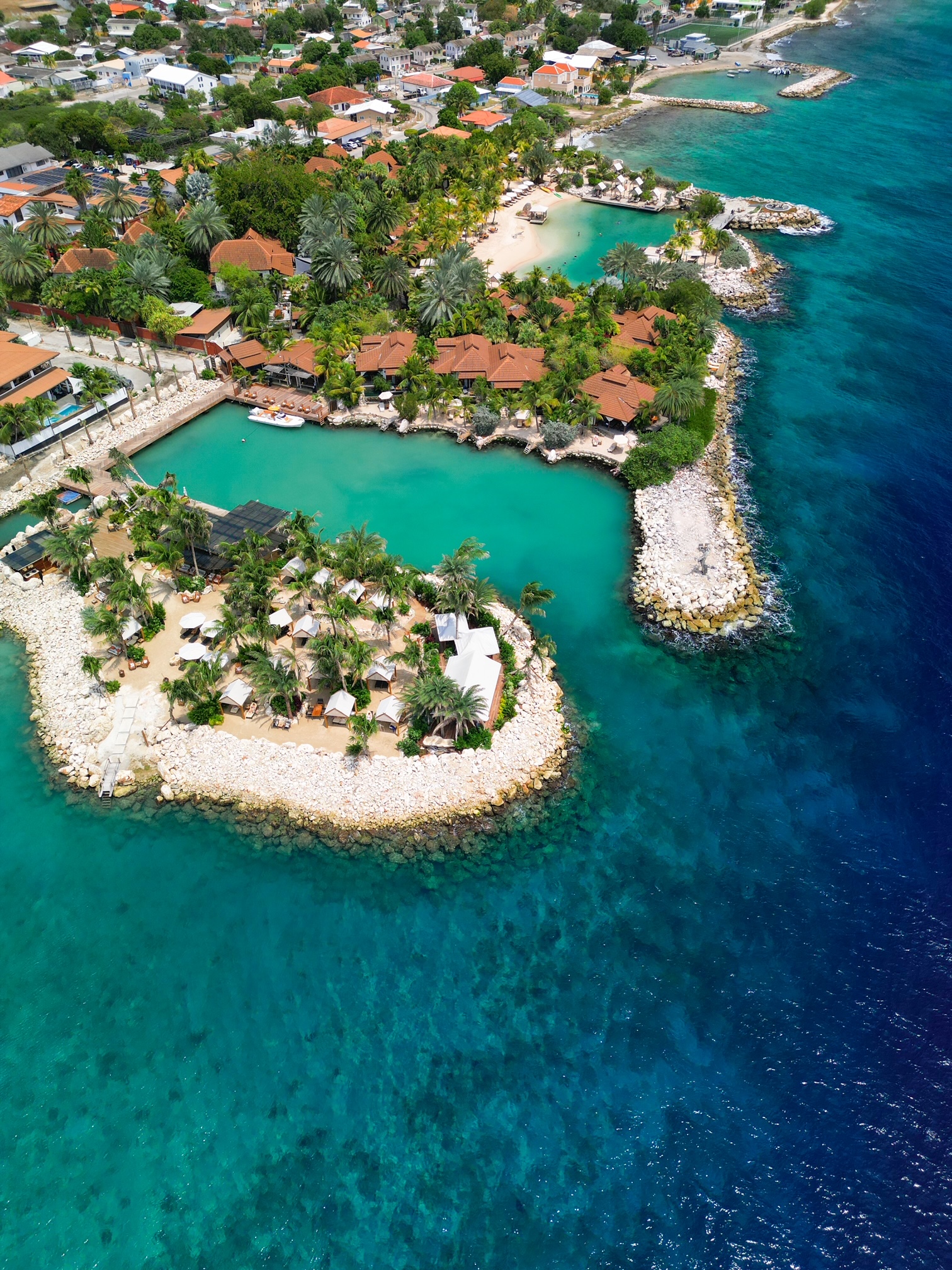 drone of Baoase luxury resort Curacao showcasing their private island and red roof buildings 