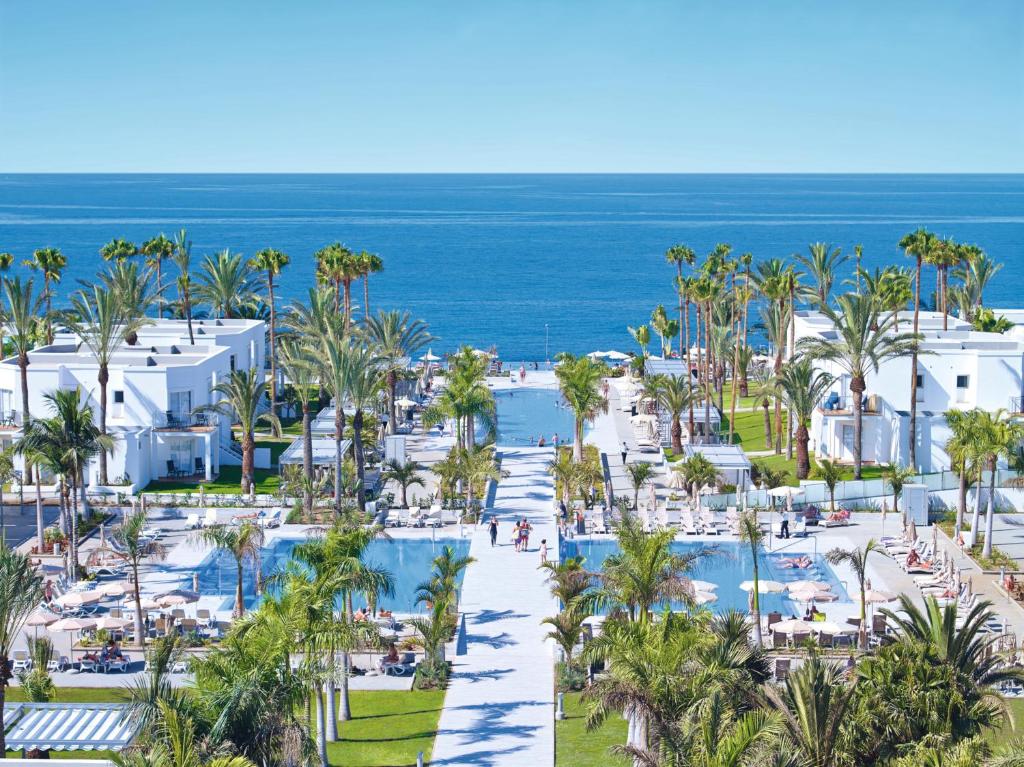 various hotel pools in a complex with palm trees all around and hotel rooms in various places . One of the best all-inclusive resorts in Europe